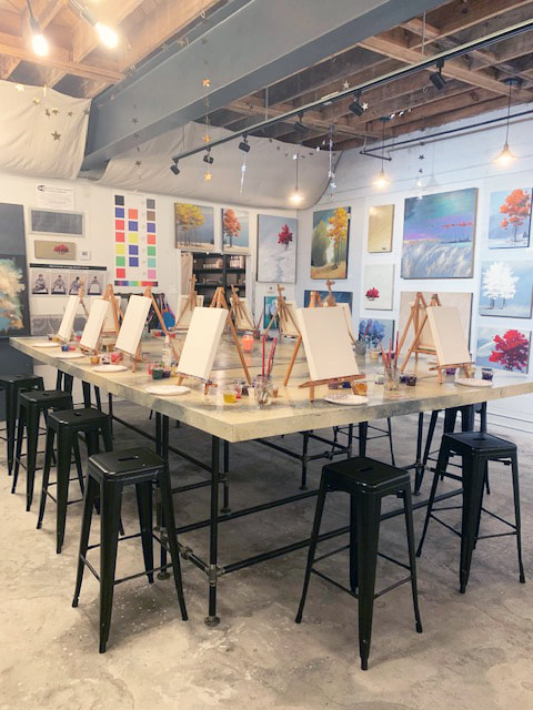 Two people laughing while painting at the studio