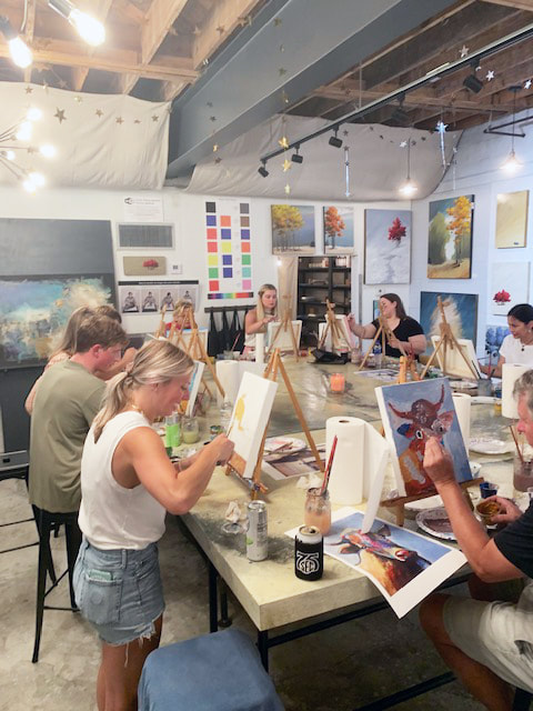 Paint supplies and canvases laid out on studio tables