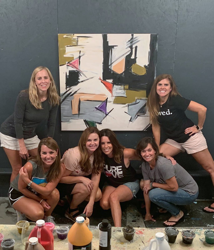 Friends laughing during a Girls' Night private paint party at the Homewood studio