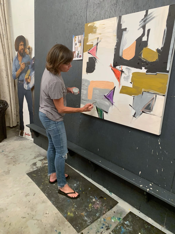Two adults painting side by side at the studio