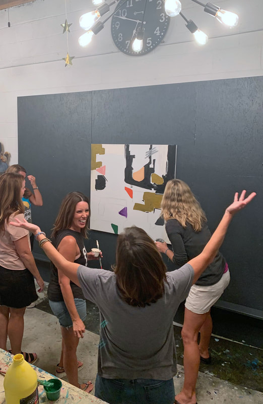 Wide shot of a full paint party in the studio