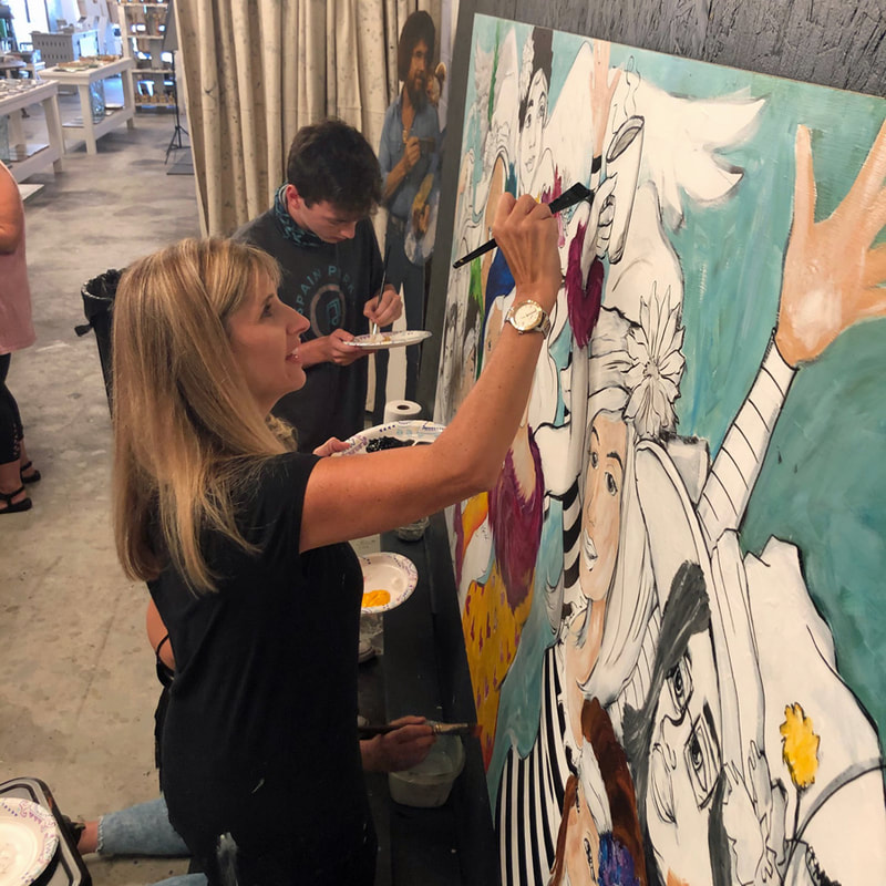 Girls' night paint party participants showing off their canvases