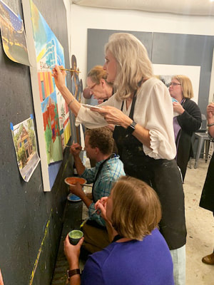 Participants collaborating on a group mural canvas.